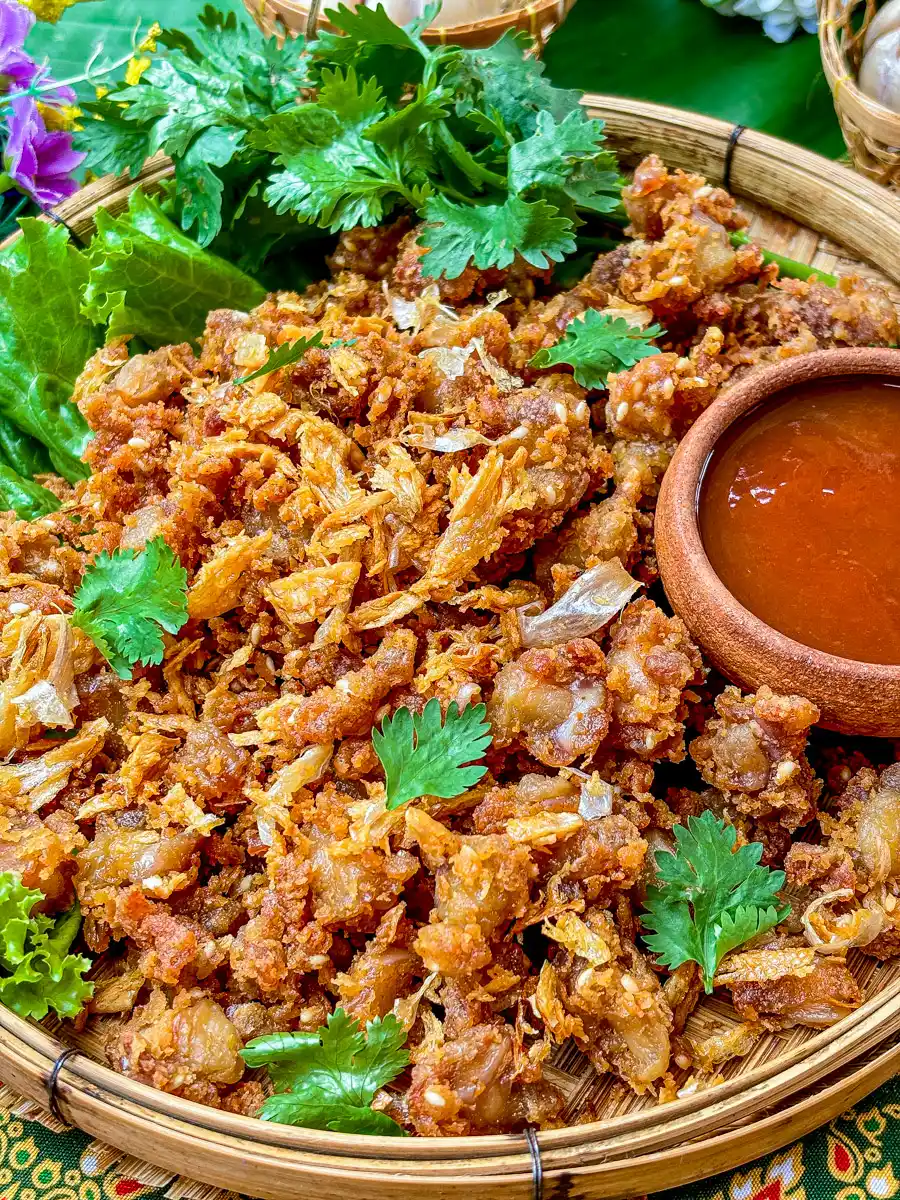 Fried chicken knuckles, garnished with fried garlic and coriander, served with Thai hot sauce.