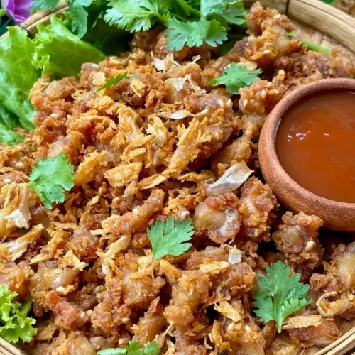 Fried chicken knuckles, garnished with fried garlic and coriander, served with Thai hot sauce.