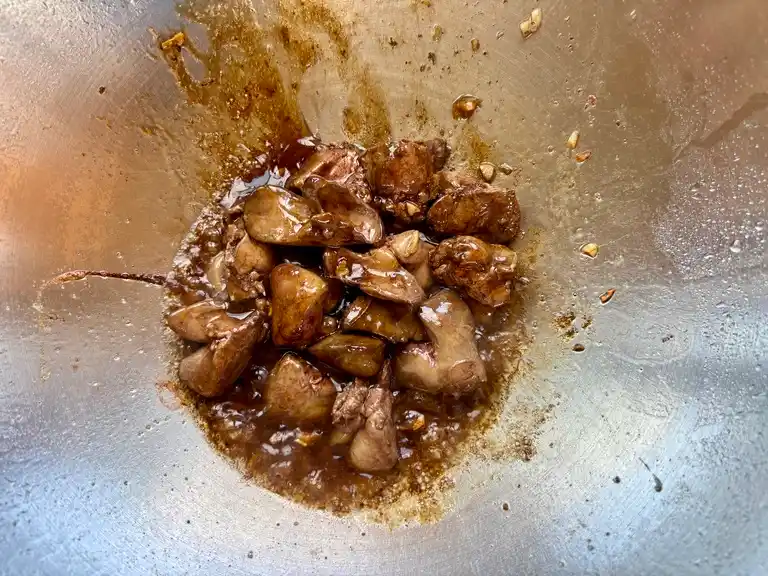 Chicken livers simmered in a tasty soy-based sauce in a wok.