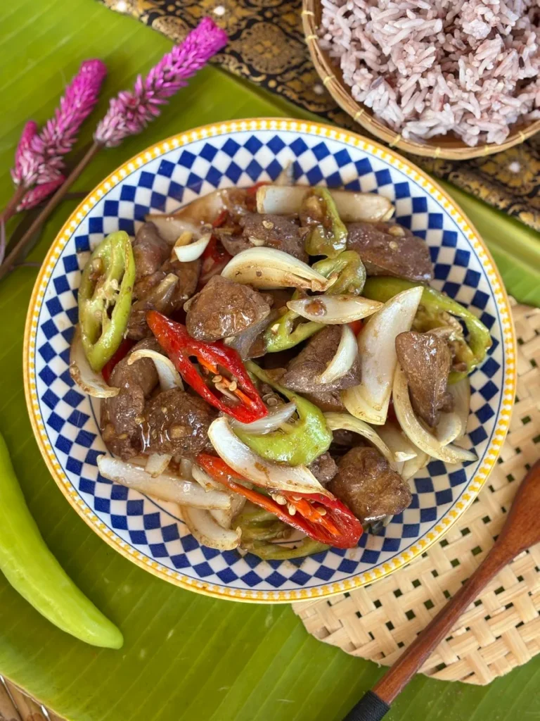 Pan-fried chicken liver with chillies and onions served in a blue and white decorative bowl.