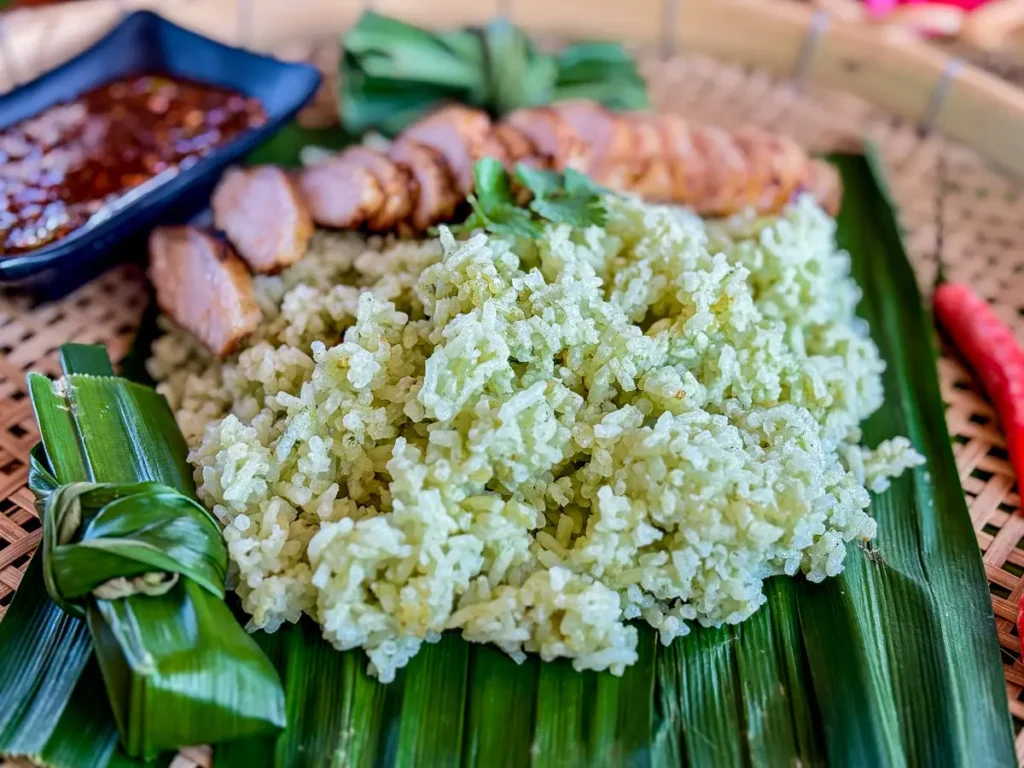 Close-up of soft and fluffy pandan rice served on a traditional banana leaf.