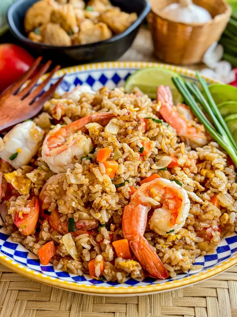 Thai shrimp fried rice dish featuring juicy shrimp, stir-fried rice, and colorful vegetables with a side of lime.
