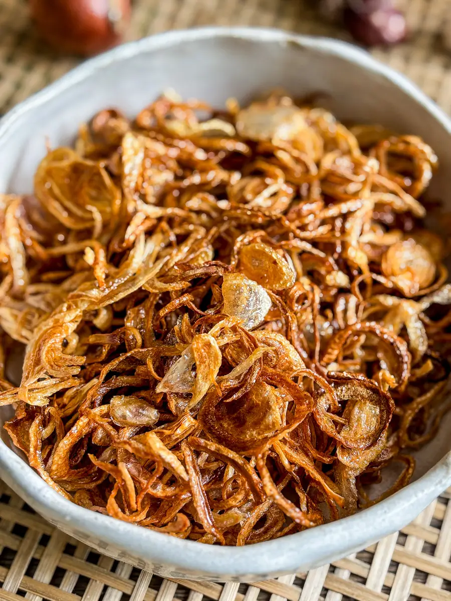 Crispy fried shallots in a ceramic bowl.