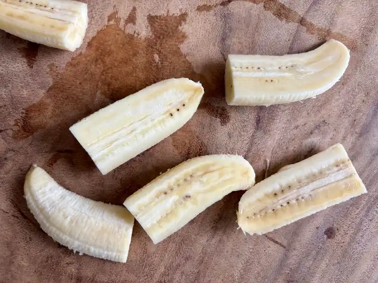 Ripe bananas sliced into halves and quarters.