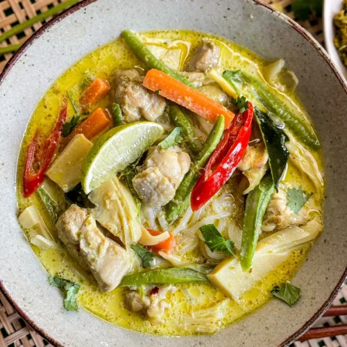 Thai green curry soup with chicken, bamboo shoots, carrots, yard long beans, and kaffir lime leaves in a coconut milk broth.