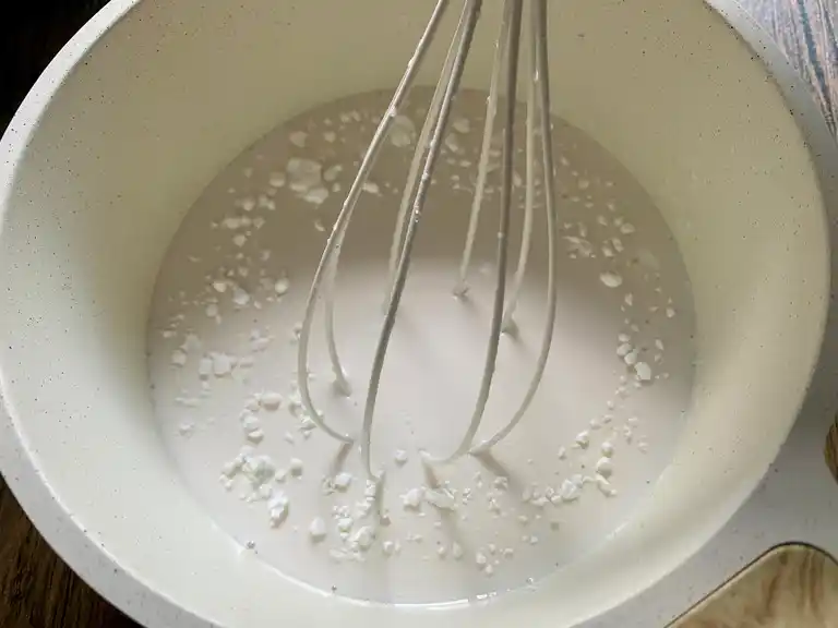 Cornstarch whisked into warm coconut milk mixture to thicken.