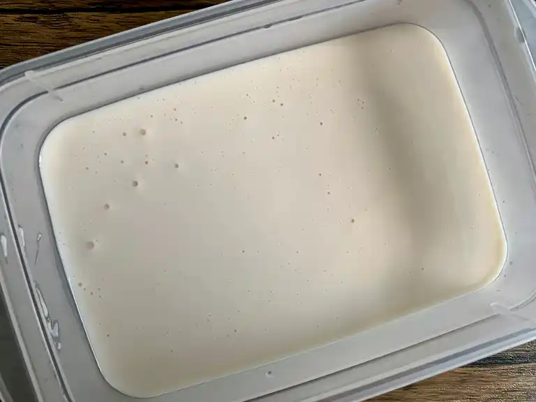 Coconut ice cream mixture poured into a container before freezing.