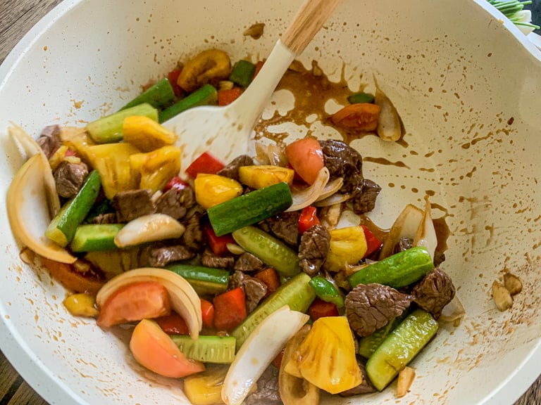 A carne voltou à panela e misturada com legumes e molho agridoce.