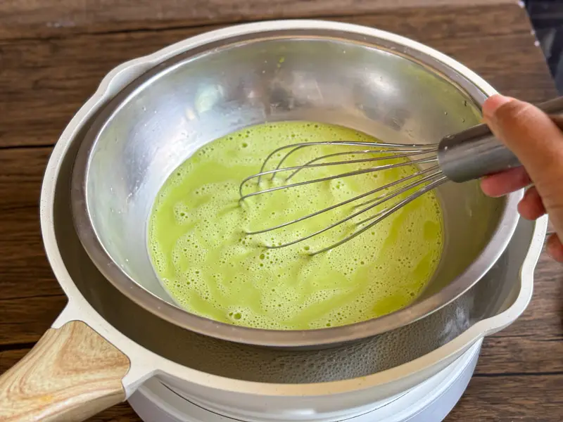 Pandan custard cooking in a heatproof bowl.