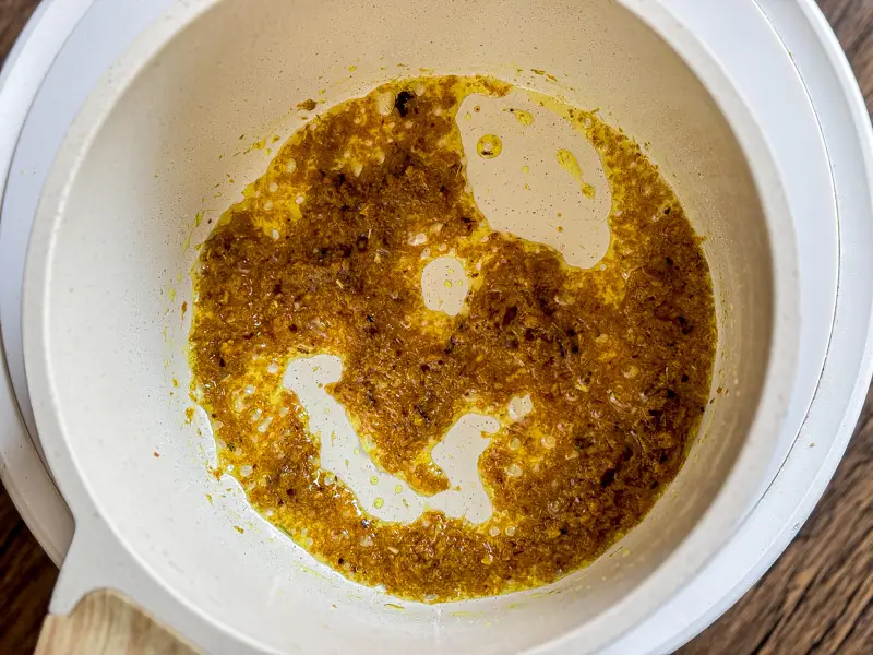 Yellow curry paste fried in oil in a pan.