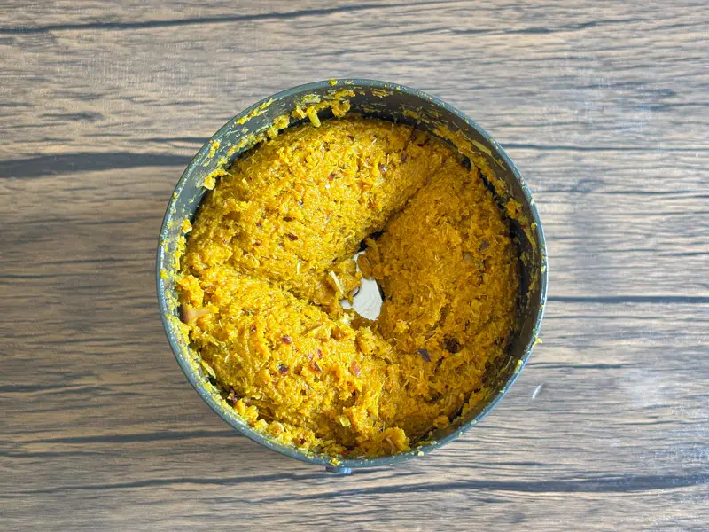 Freshly blended homemade yellow curry paste in a food processor.