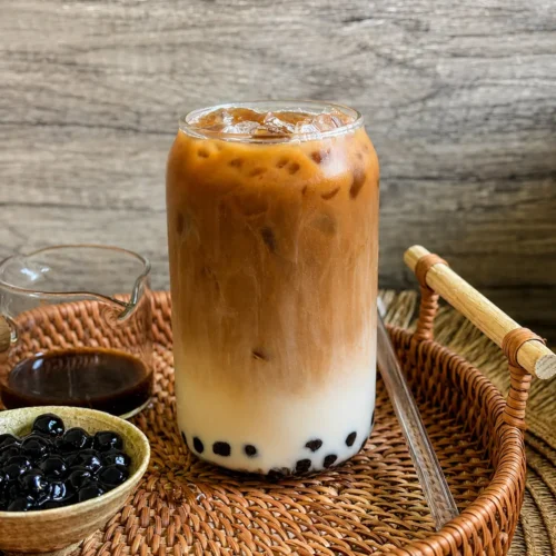 Thai iced coffee boba with tapioca pearls and creamy milk served over ice in a glass jar.