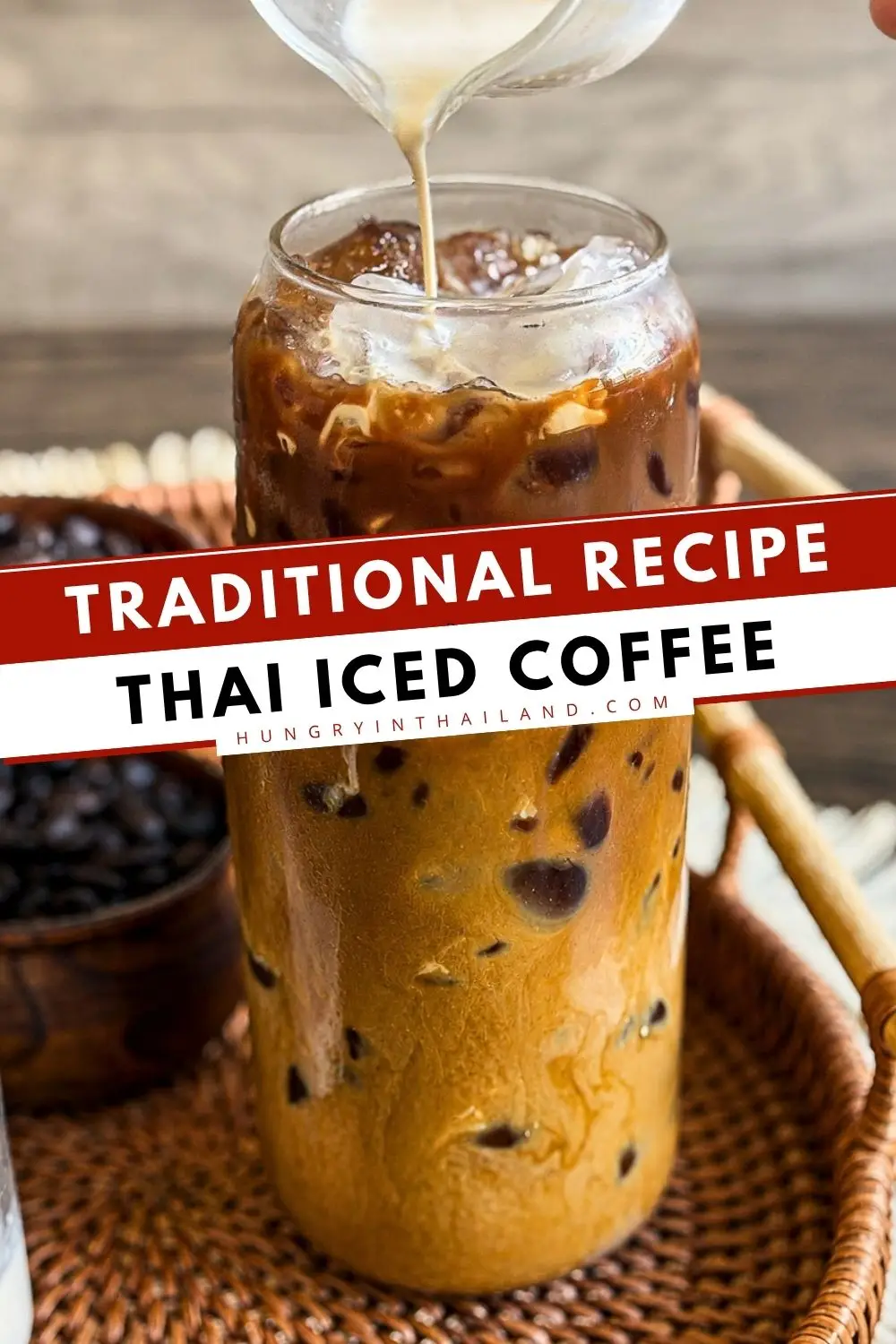 Traditional Thai iced coffee with sweetened condensed milk and evaporated milk poured over ice in a tall glass.