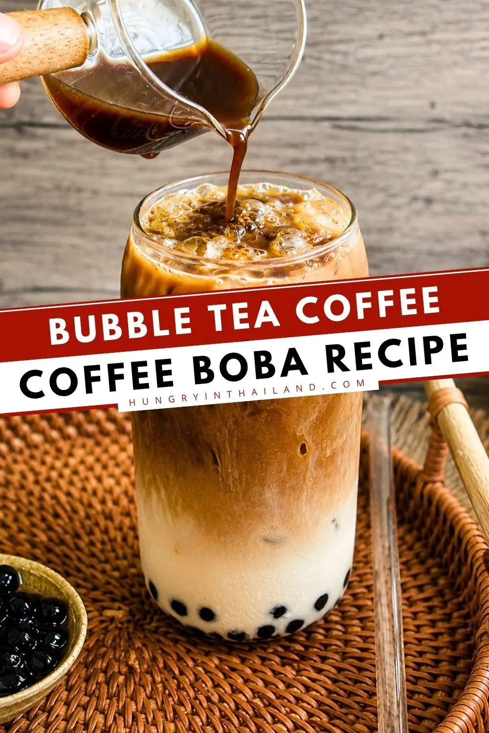 Bubble tea coffee served over ice with chewy tapioca pearls and creamy milk while fresh coffee is poured into the glass.