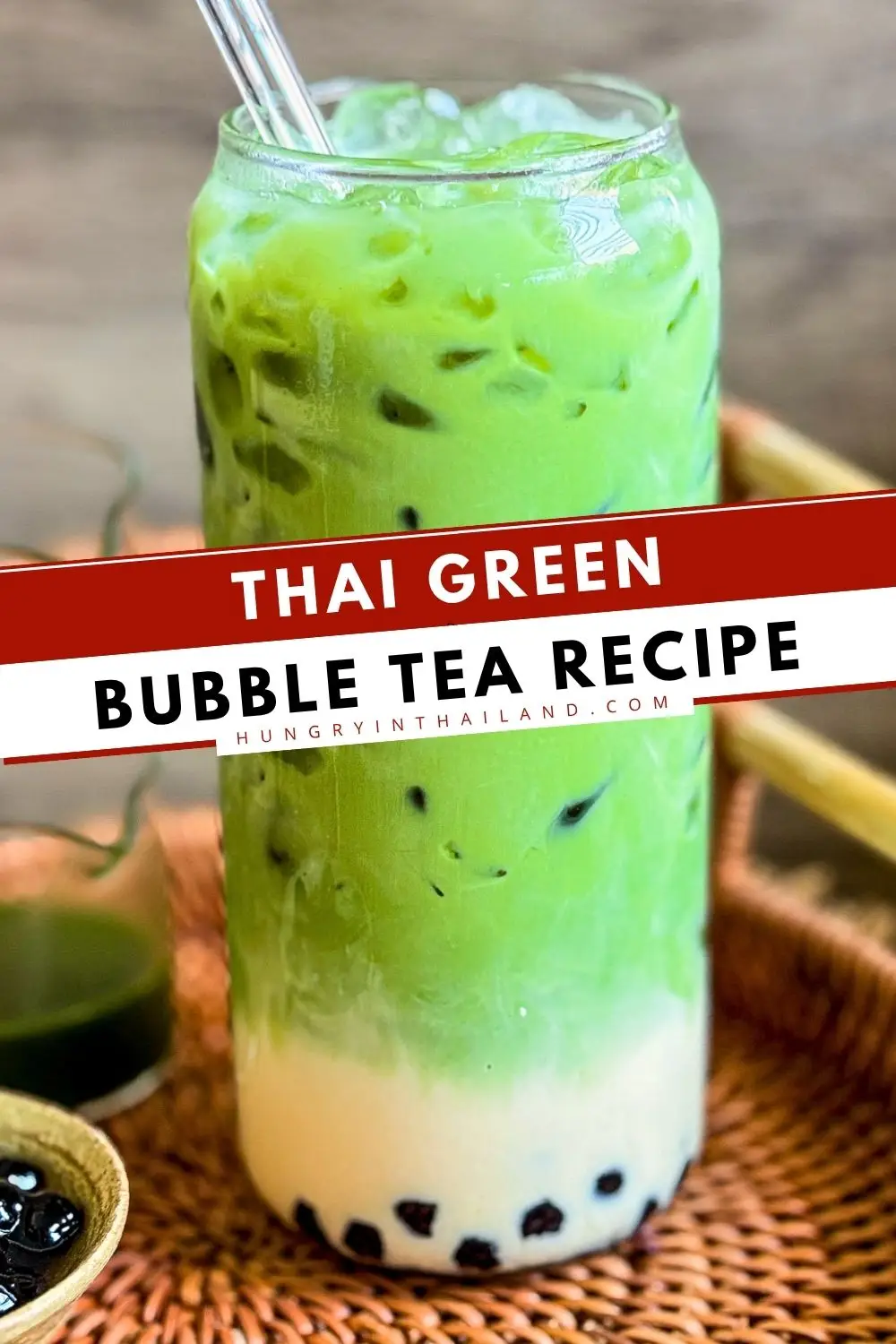 Thai green bubble tea served over ice with chewy tapioca pearls in a tall glass.