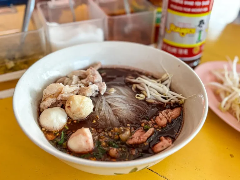 Authentic Thai noodle soup served with traditional noodle soup condiments in the background before seasoning.