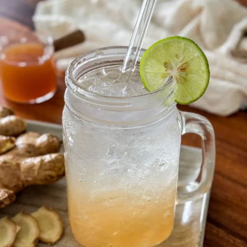 Homemade ginger soda with ice and fresh lime.