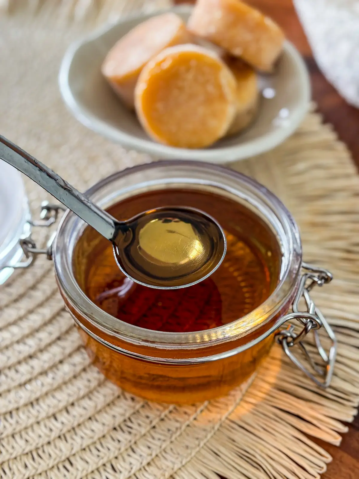 Homemade palm sugar syrup in a glass jar with a spoon.