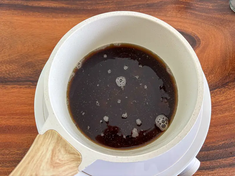 Brown sugar syrup simmering in a saucepan.