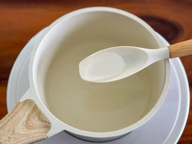 1. Testing the consistency of homemade simple syrup with a spoon.